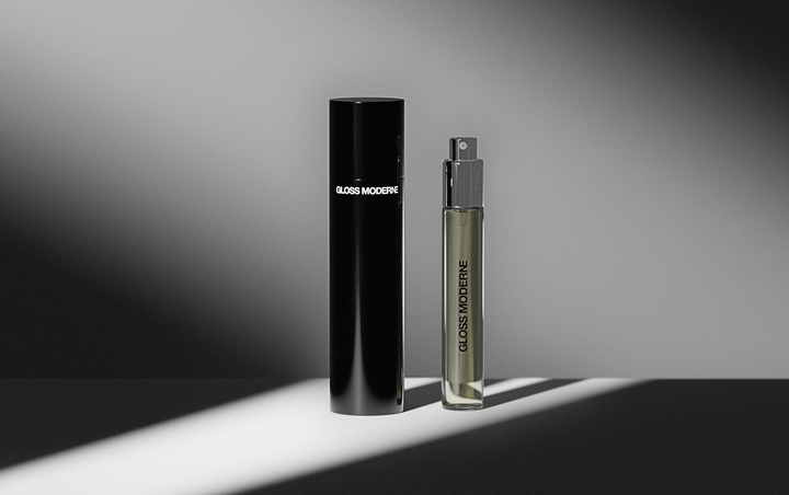 Travel fragrance and container stood on a white table with strong contrast lighting