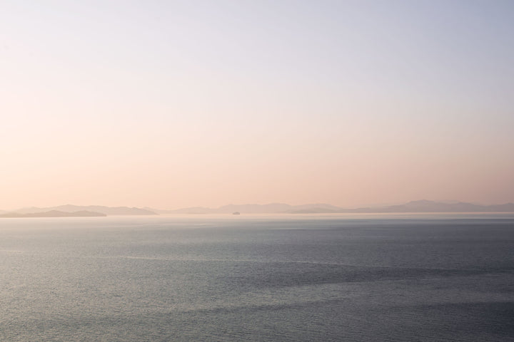 sunset ocean photograph with distant islands